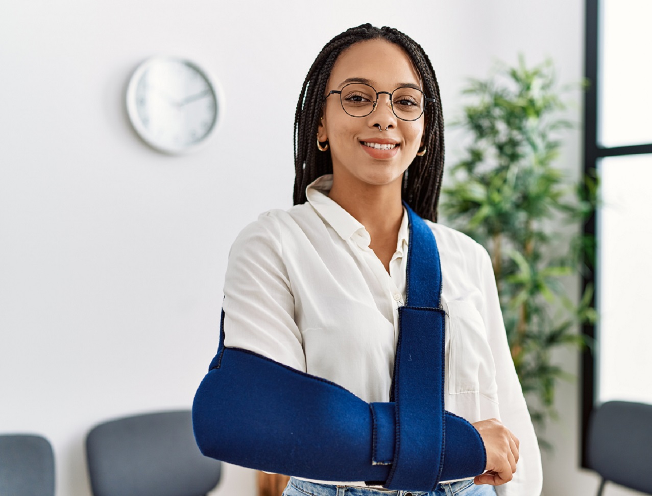 Young woman is smiling and wearing a cast for injured arm.
