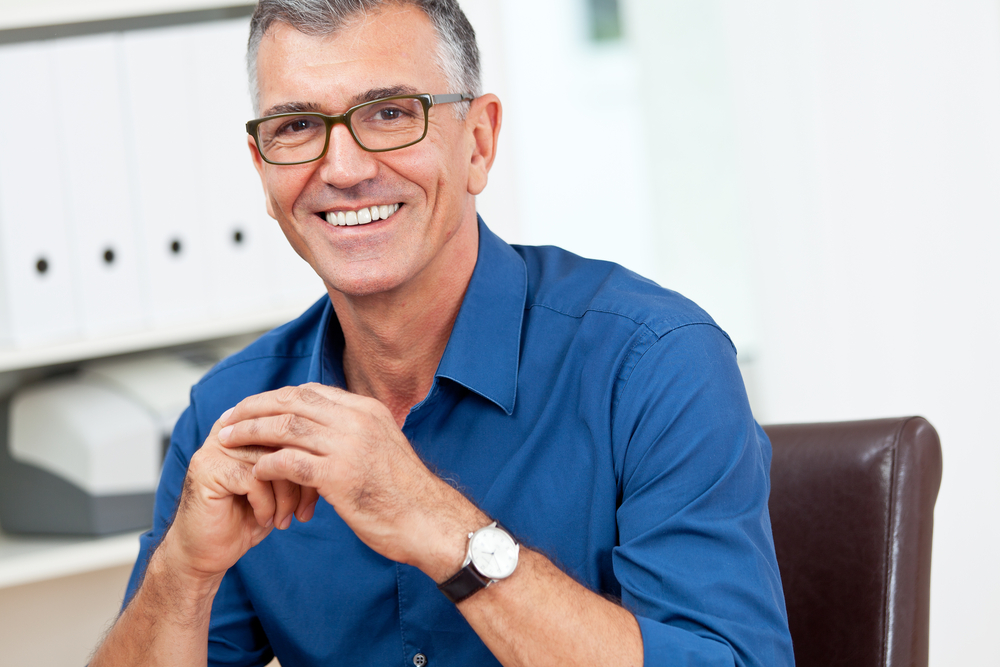 Employee sitting at his desk talking to someone