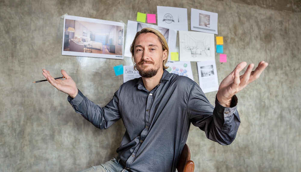 Closeup portrait of upset man lifting his hands sitting on a chair in office