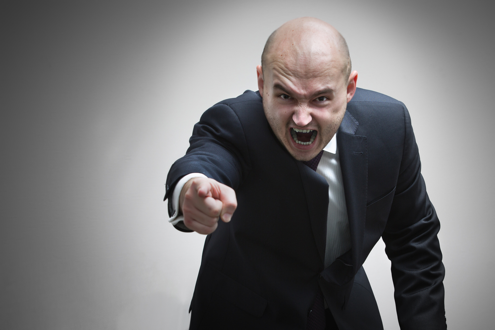 Angry manager  yelling and pointing at the camera
