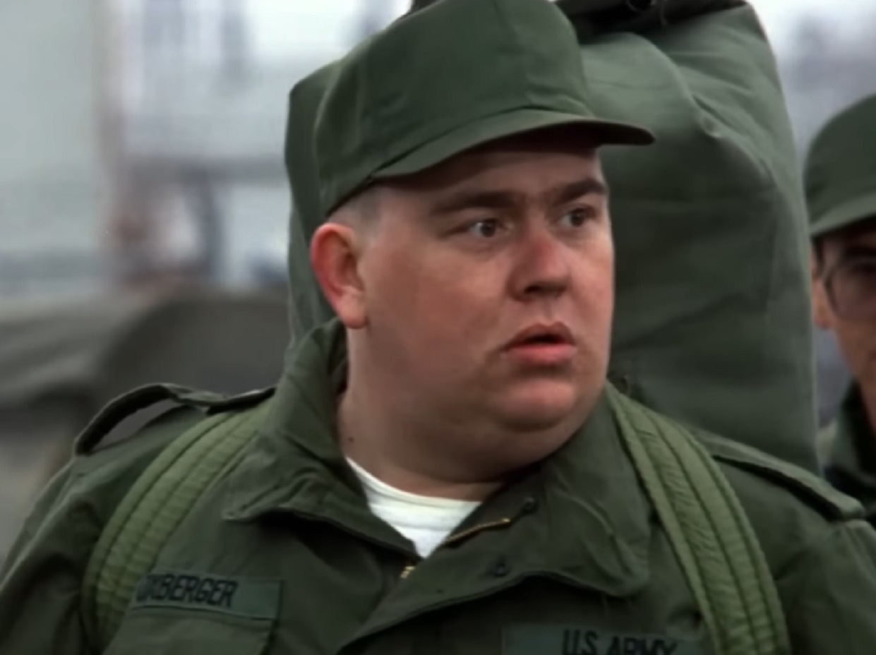 Screenshot :John Candy wearing military uniform is looking at side - from Stripes (1981)