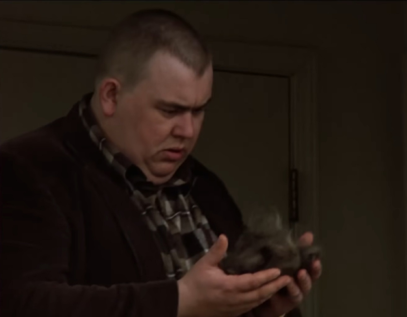 Screenshot :John Candy is holding a hair in his arms and looking sad - from Stripes (1981)