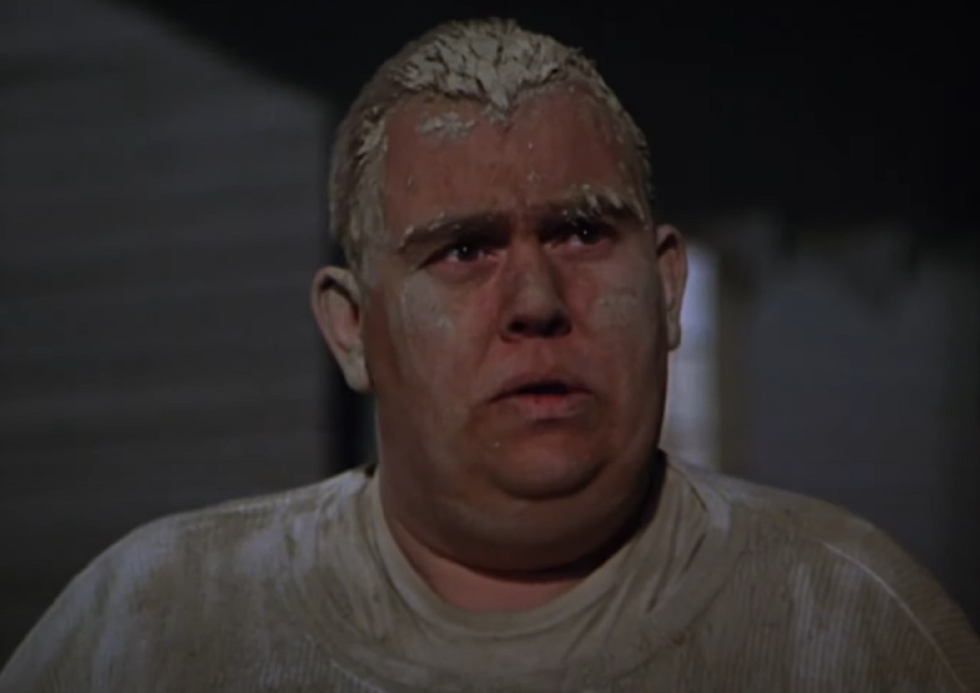 Screenshot :John Candy wearing muddy shirt is looking at side - from Stripes (1981)