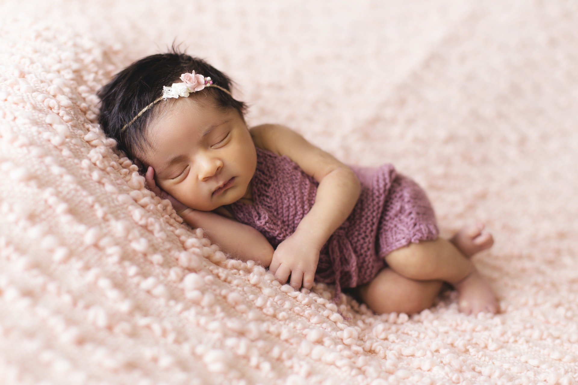 Newborn baby sleeping on pink blanket
