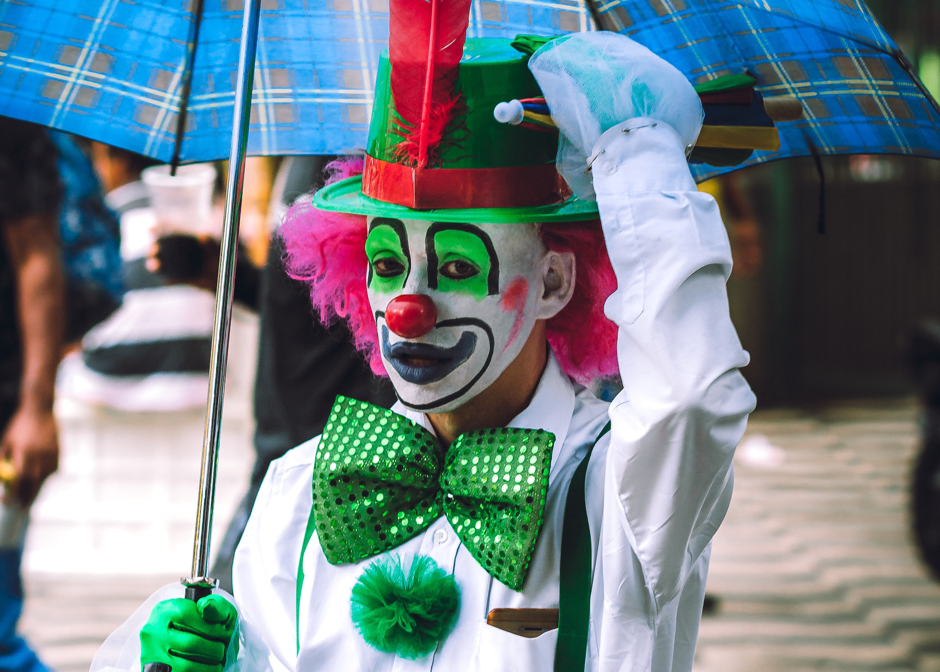 Scary clown with makeup and costume on street