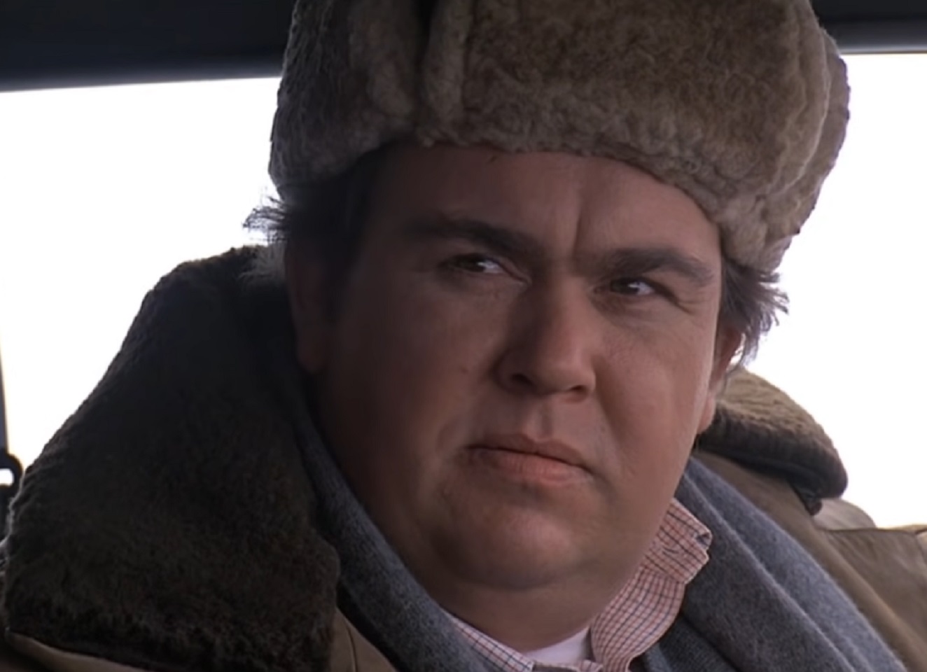 Screenshot :John Candy wearing big grey coat and winter hat on his head - from Uncle Buck (1989)