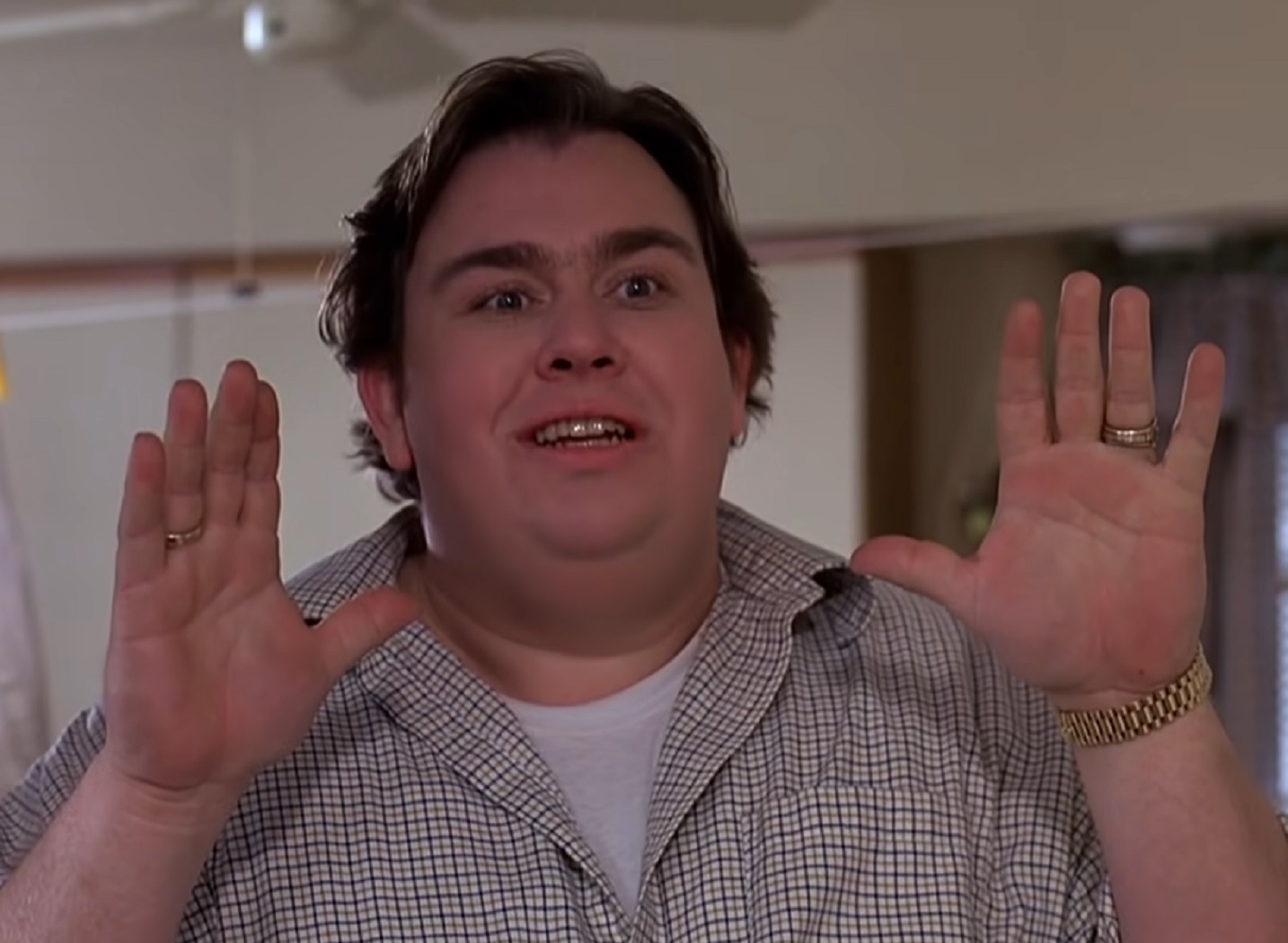 Screenshot :John Candy wearing beige shirt is standing with arms up and talking - from Uncle Buck (1989)