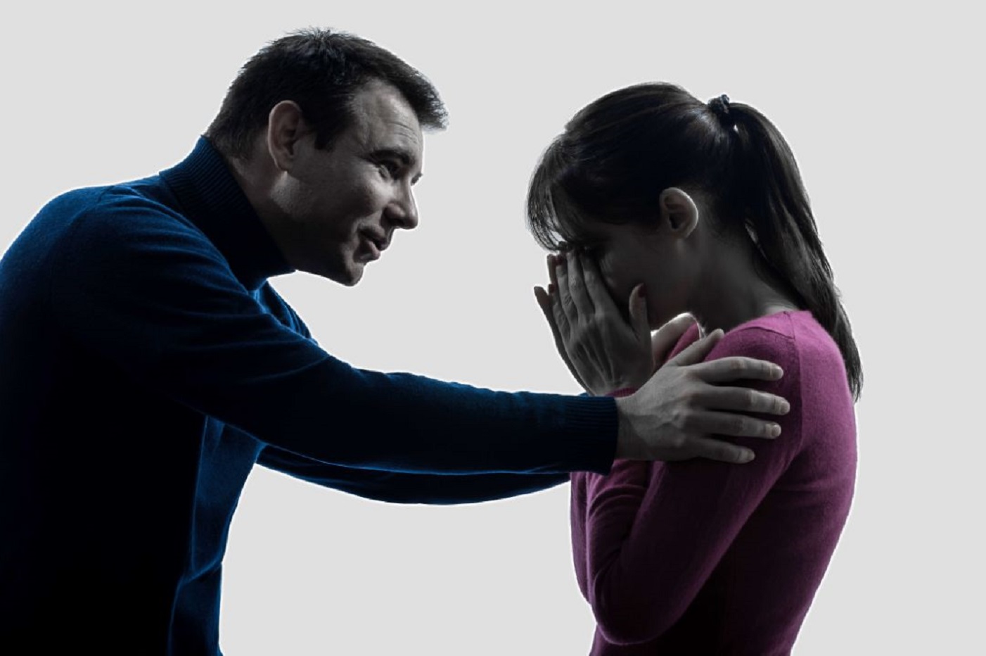 Man is consoling a crying woman wearing pink shirt.