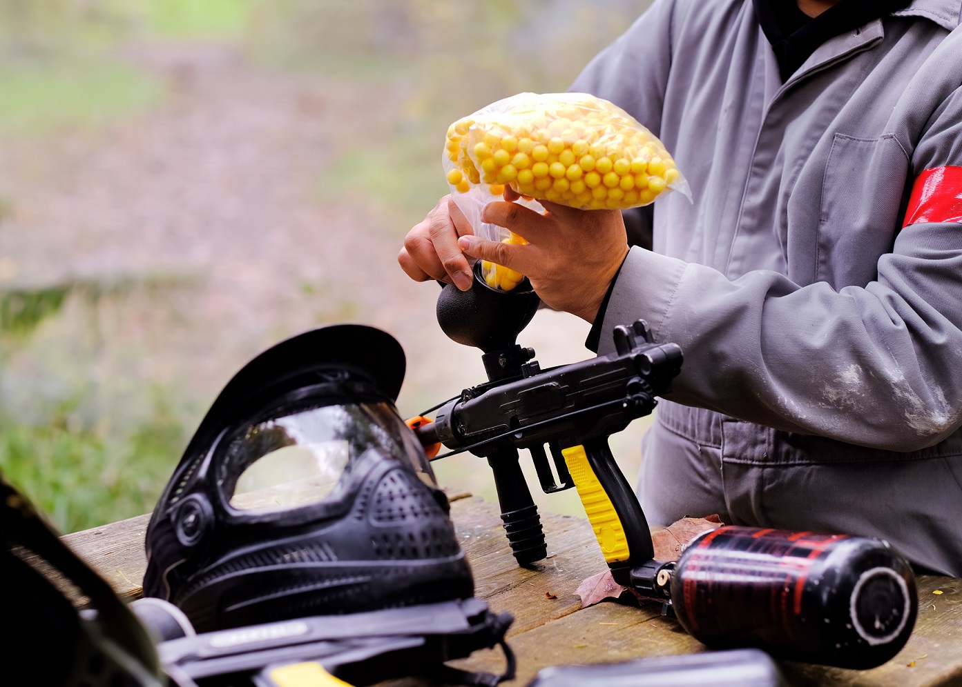 Man is reloading yellow paintballs to paintball gun.