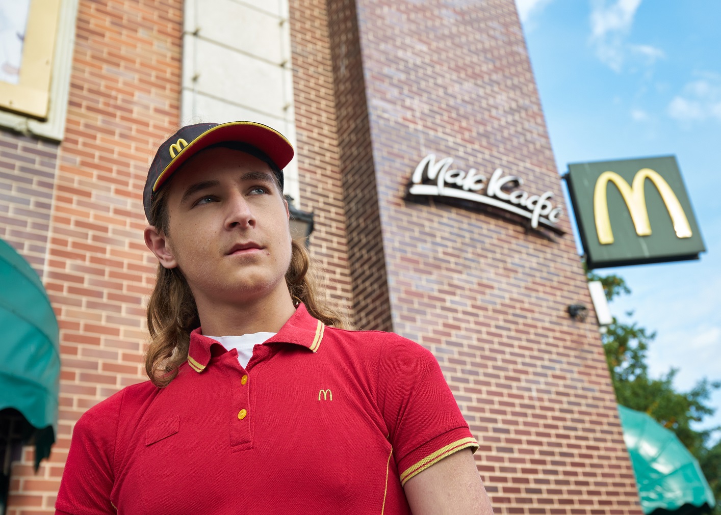 Teenager posing against the background of McDonald's restaurant.