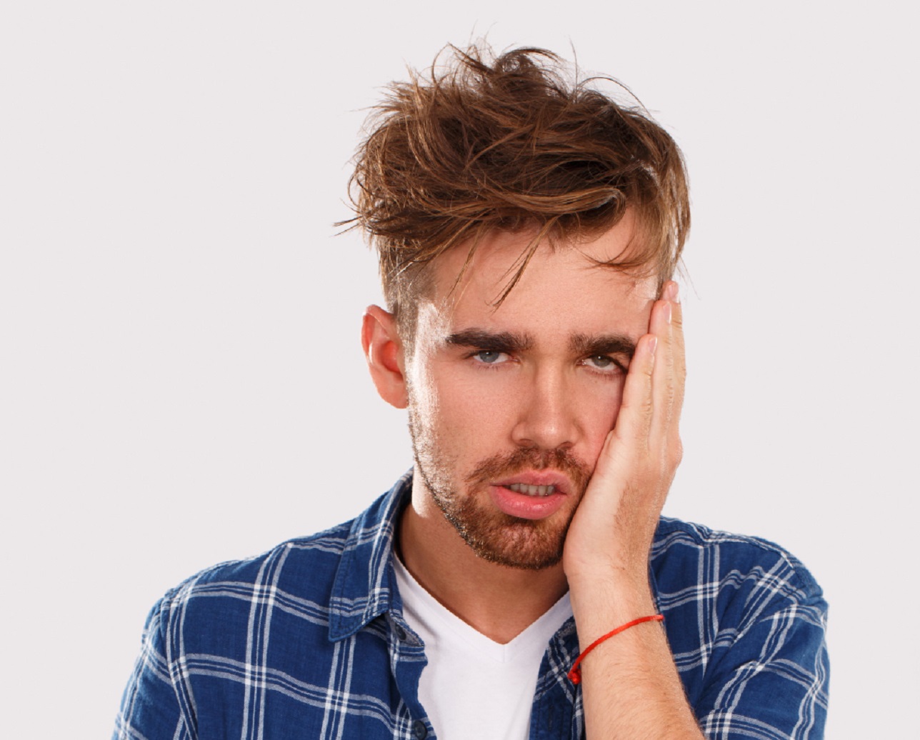 Young bearded man with messy hair is looking drunk.