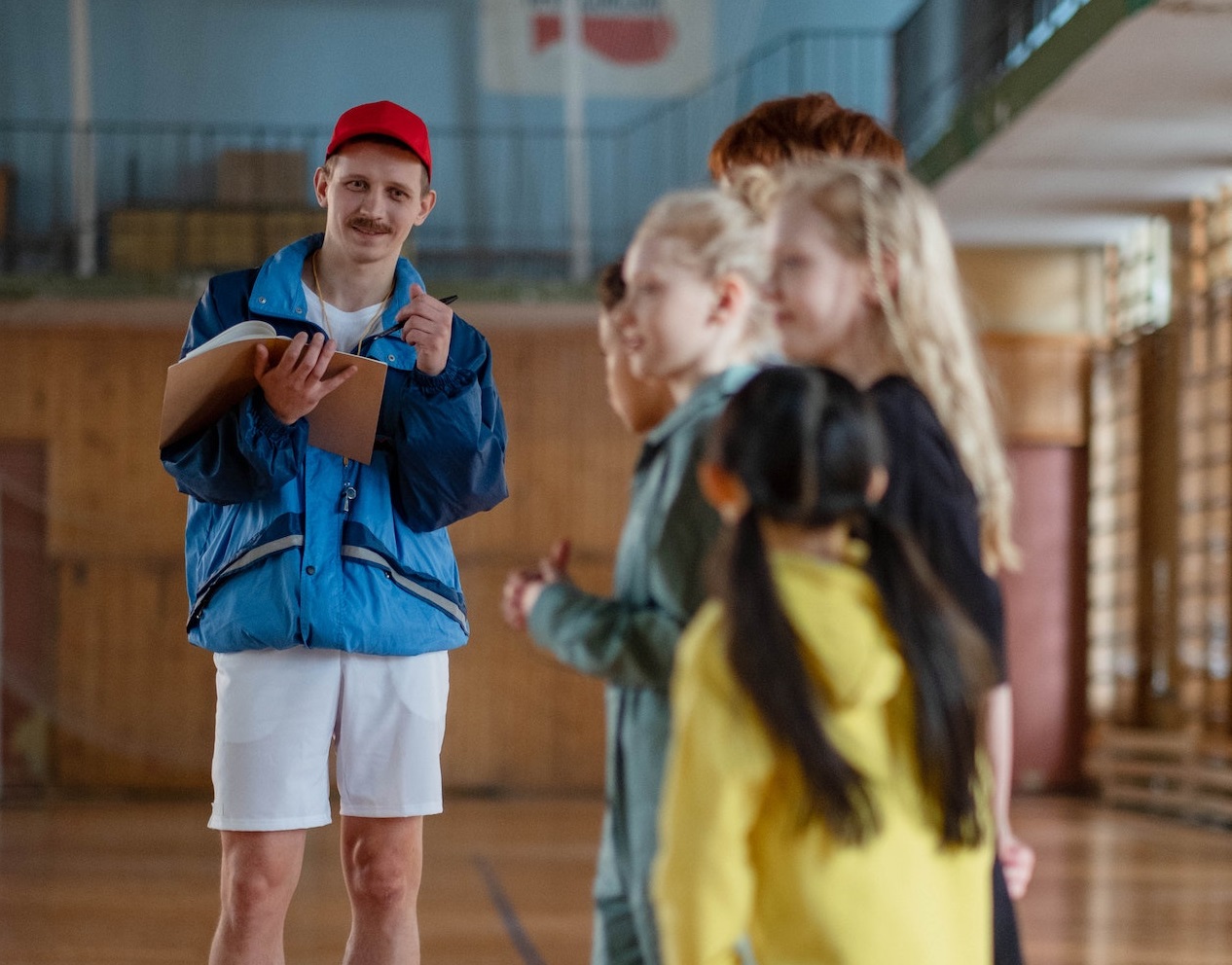 Gym teacher is holding a class at school with students.