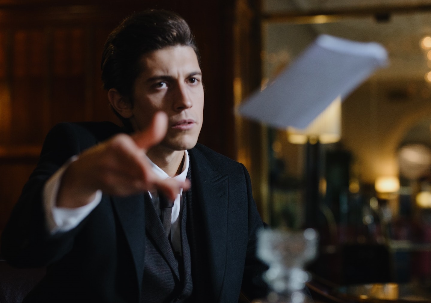 Young man with upset face is throwing a paper in front of him.