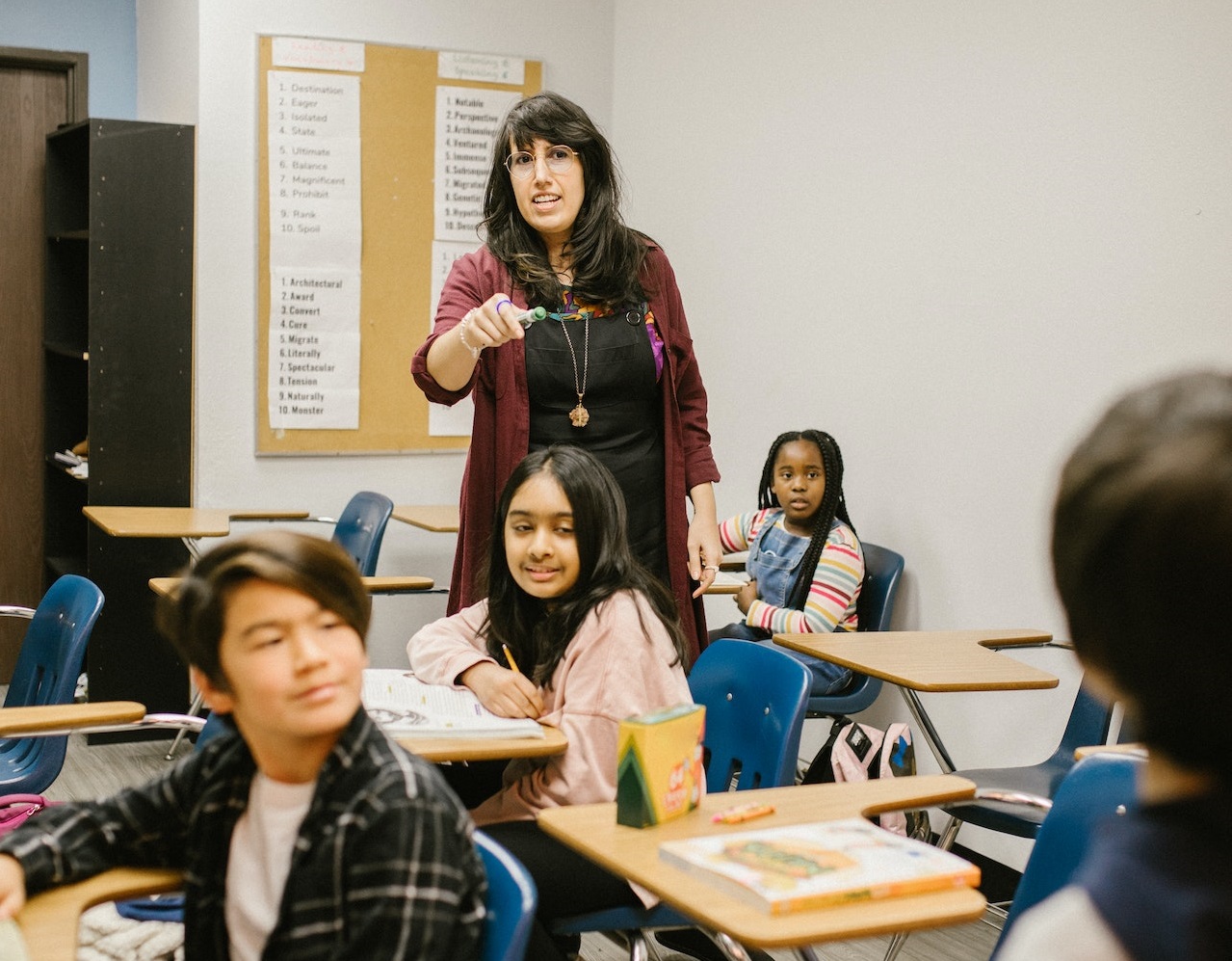 Female teacher is pointing and talking to a student at class.