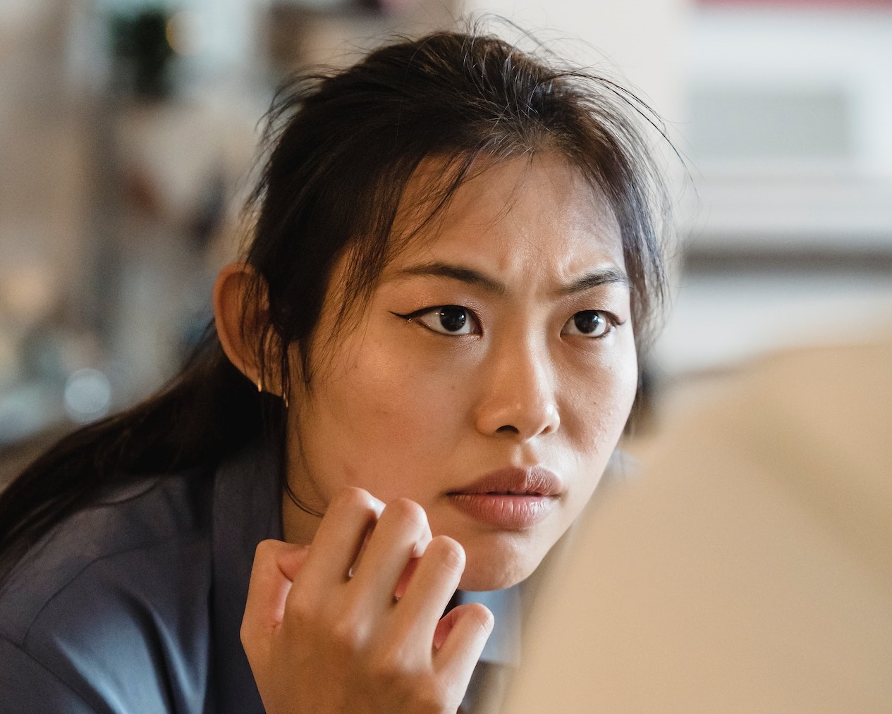 Young woman with messy hair is looking with angry face.