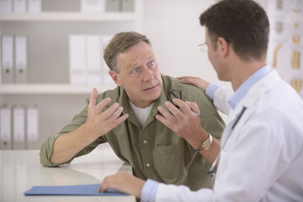 Doctor talking to mature male patient