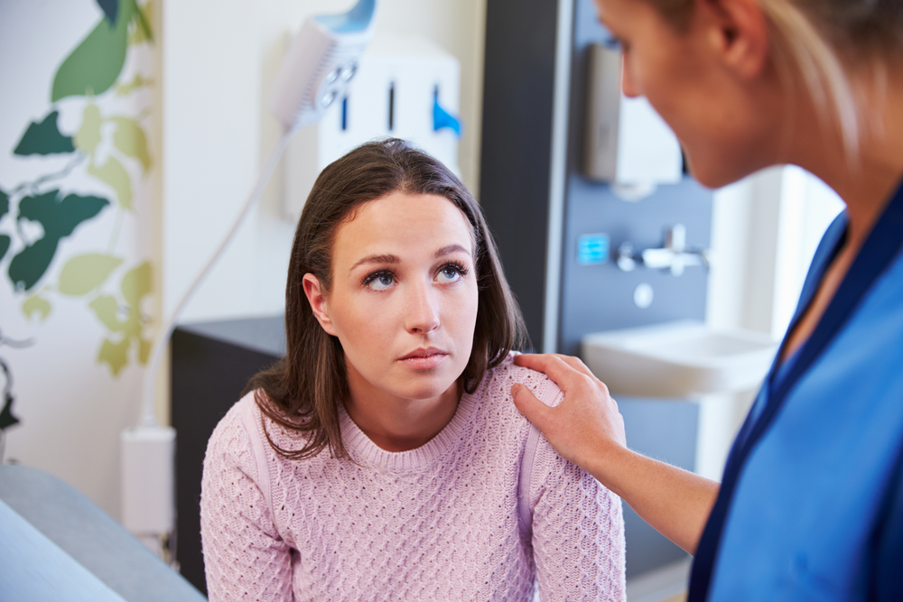Female Patient Being Reassured By Nurse