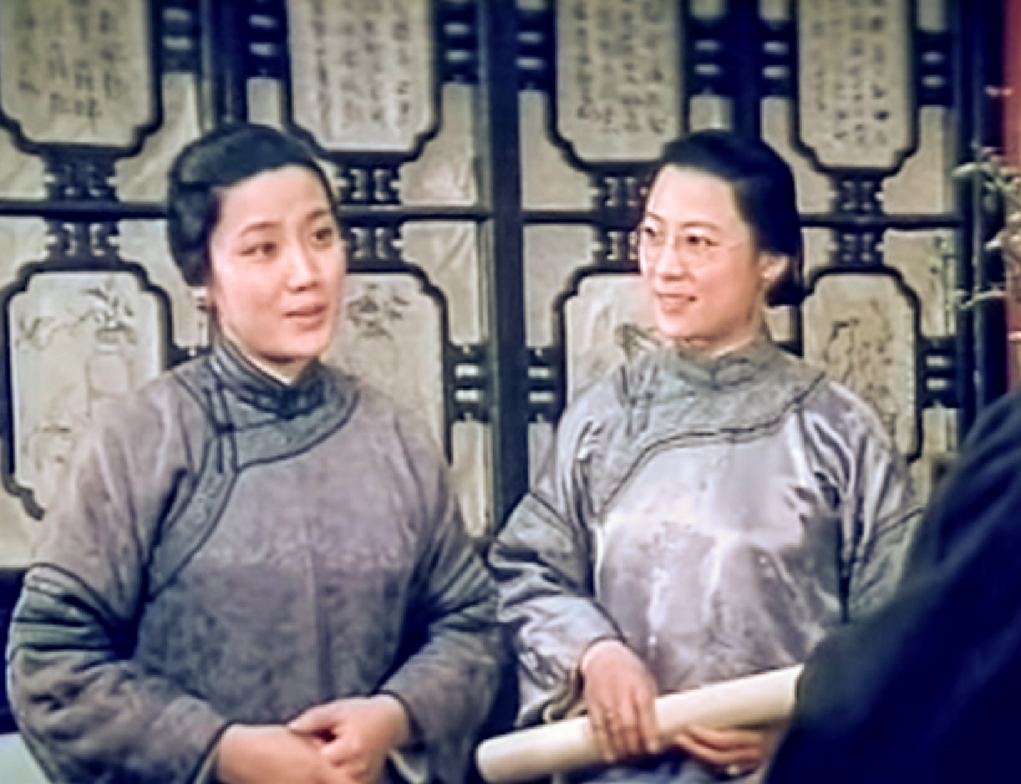 Screenshot: Qiu Jin (Xiuming Li) is seating and talking with other person - from Qiu Jin (1983)