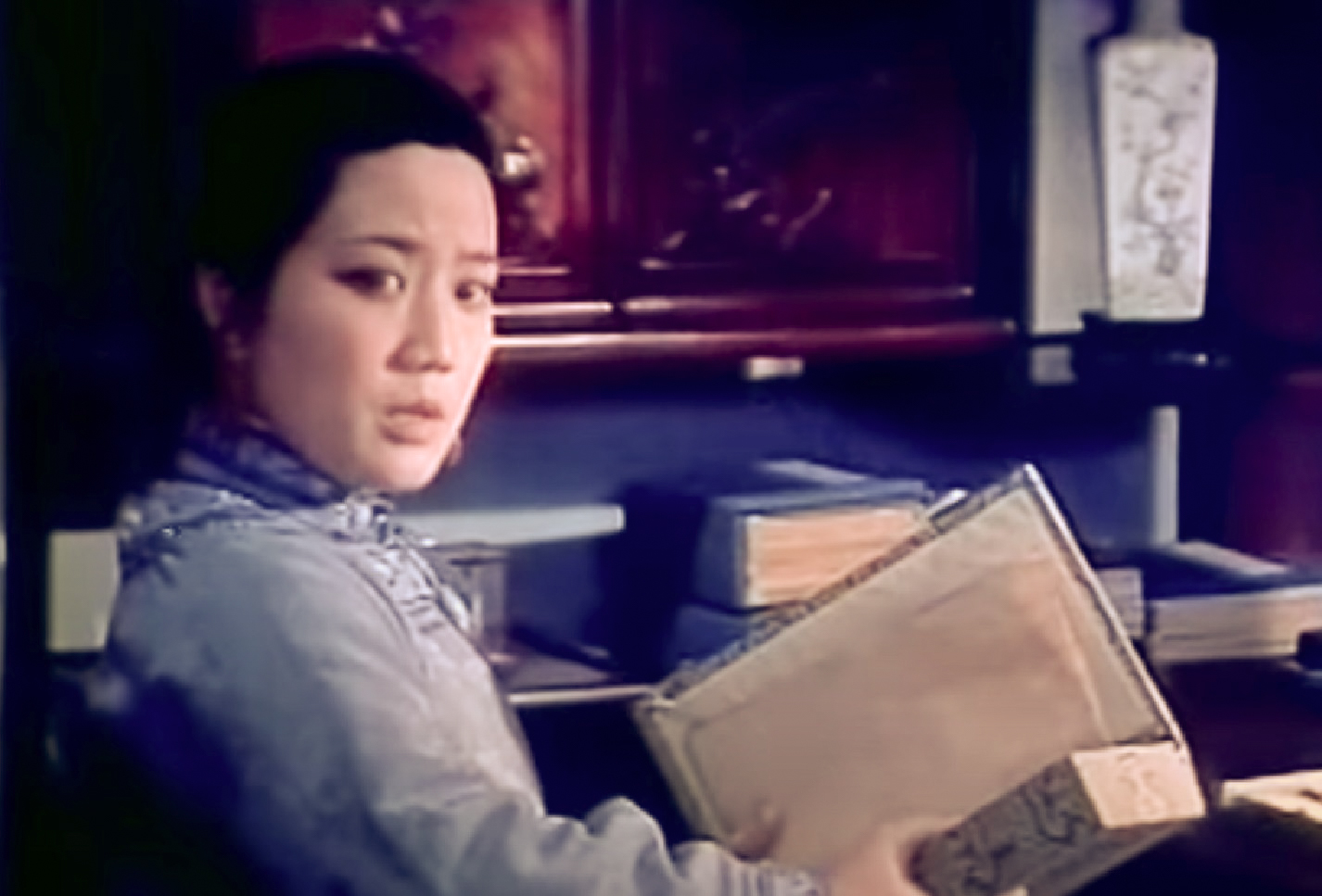 Screenshot: Qiu Jin (Xiuming Li) is holding a box and looking at side - from Qiu Jin (1983)