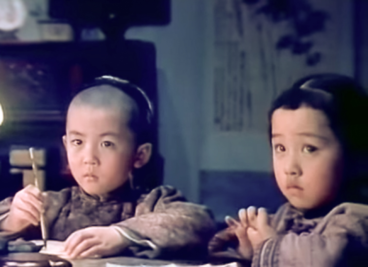 Screenshot: Qiu Jin's children are seating at table and drawing - from Qiu Jin (1983)