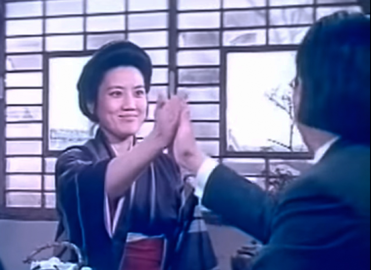 Screenshot: Qiu Jin (Xiuming Li) is talking and making a hand contact with other man - from Qiu Jin (1983)