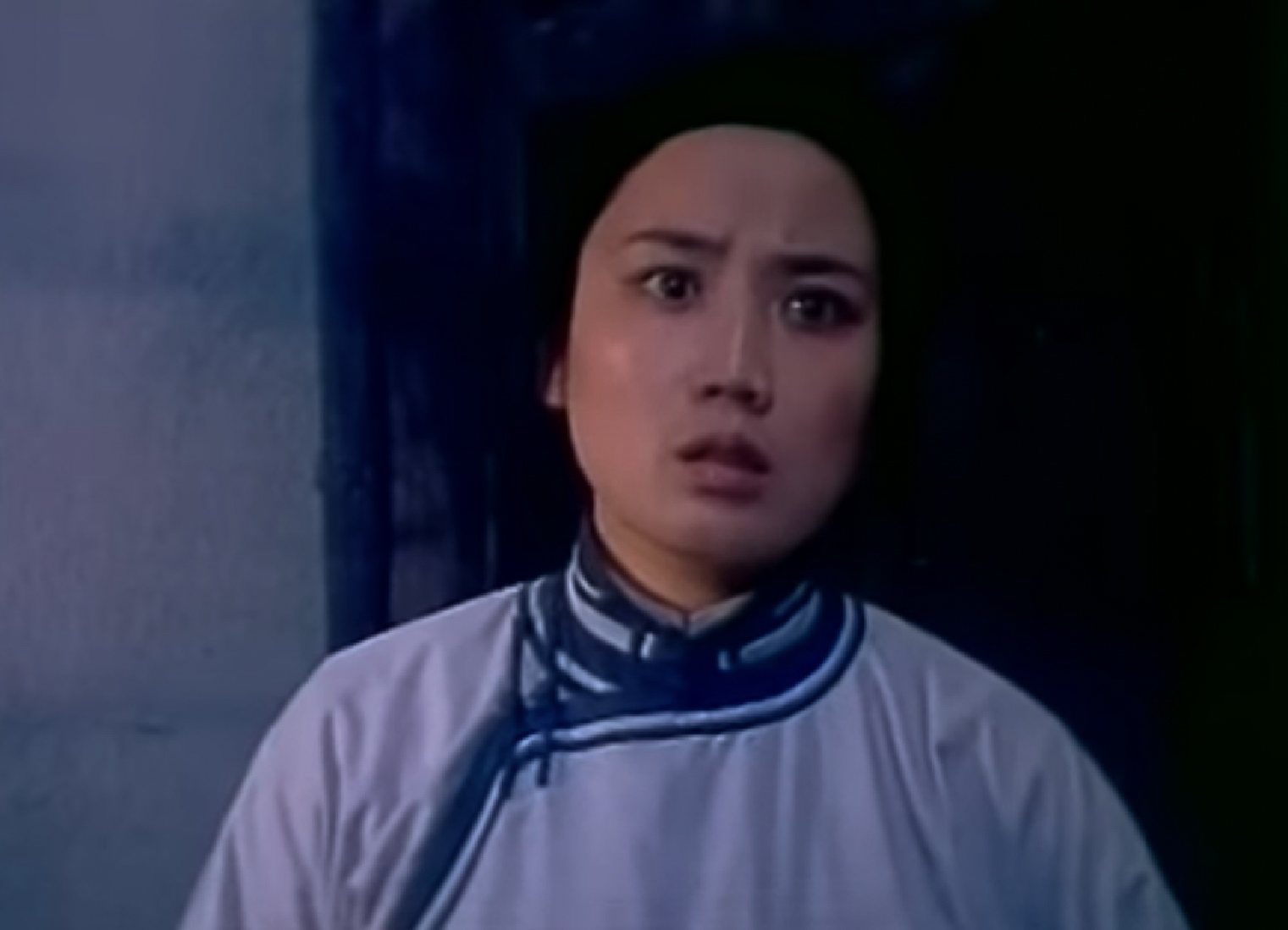 Screenshot: Qiu Jin (Xiuming Li) wearing white shirt is looking at side with sad face - from Qiu Jin (1983)