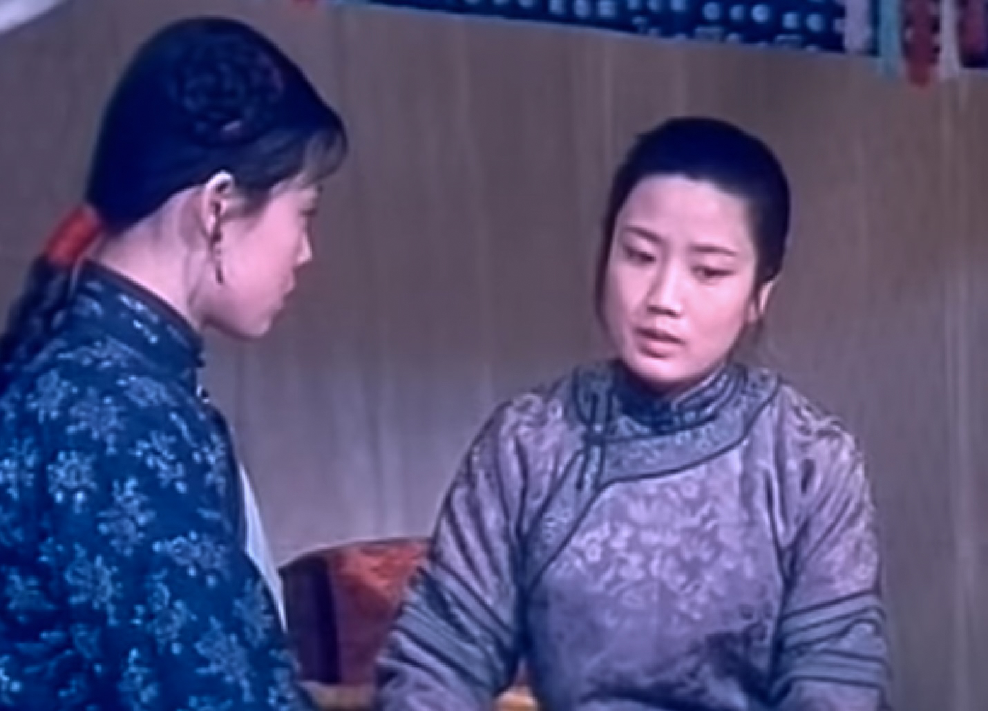 Screenshot: Qiu Jin (Xiuming Li) is talking with other woman inside a room and looking down - from Qiu Jin (1983)