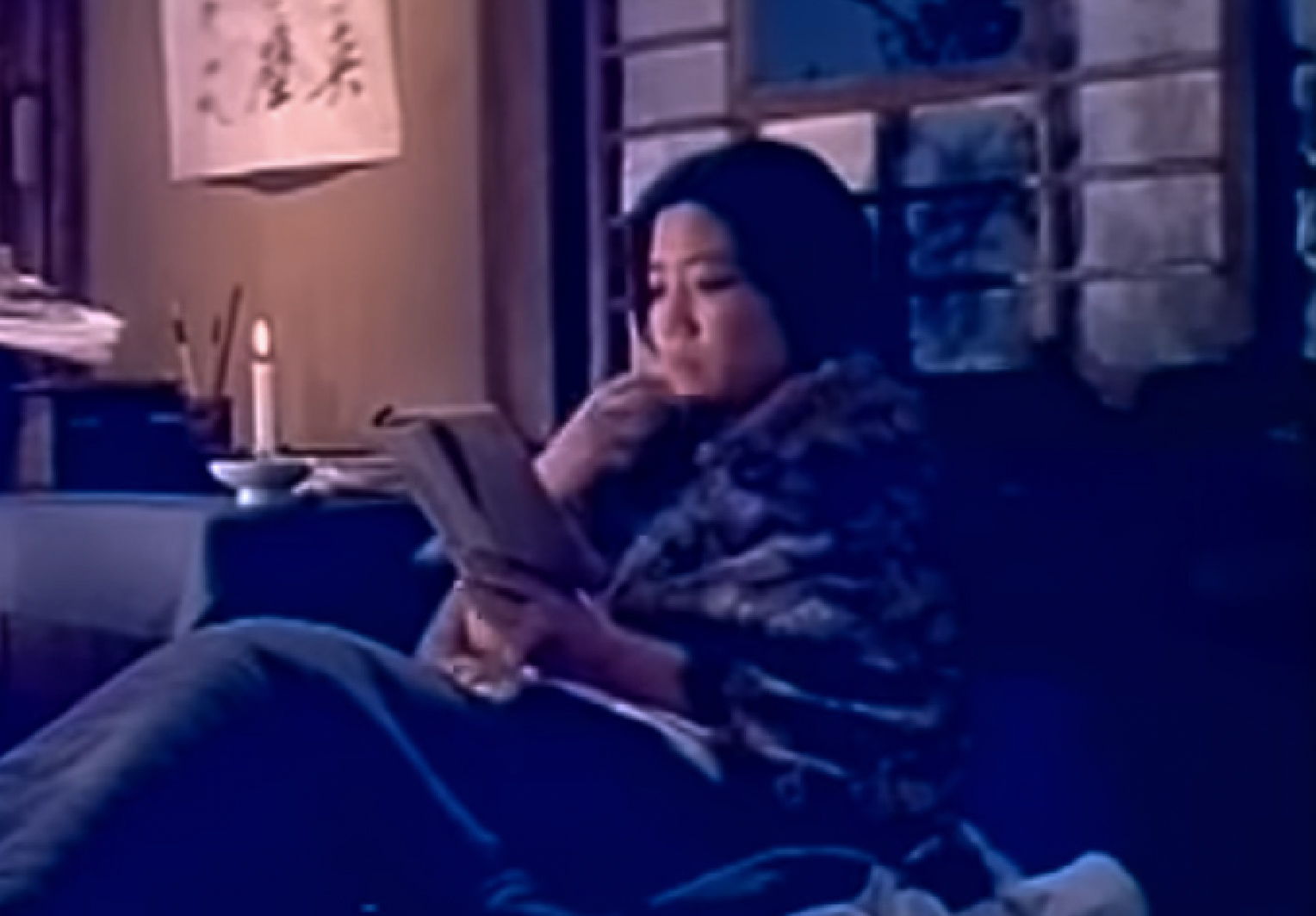 Screenshot: Qiu Jin (Xiuming Li) is reading book in the bed at night - from Qiu Jin (1983)