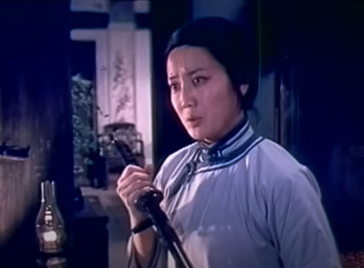 Screenshot: Qiu Jin (Xiuming Li) is looking at side and holding a katana sword - from Qiu Jin (1983)