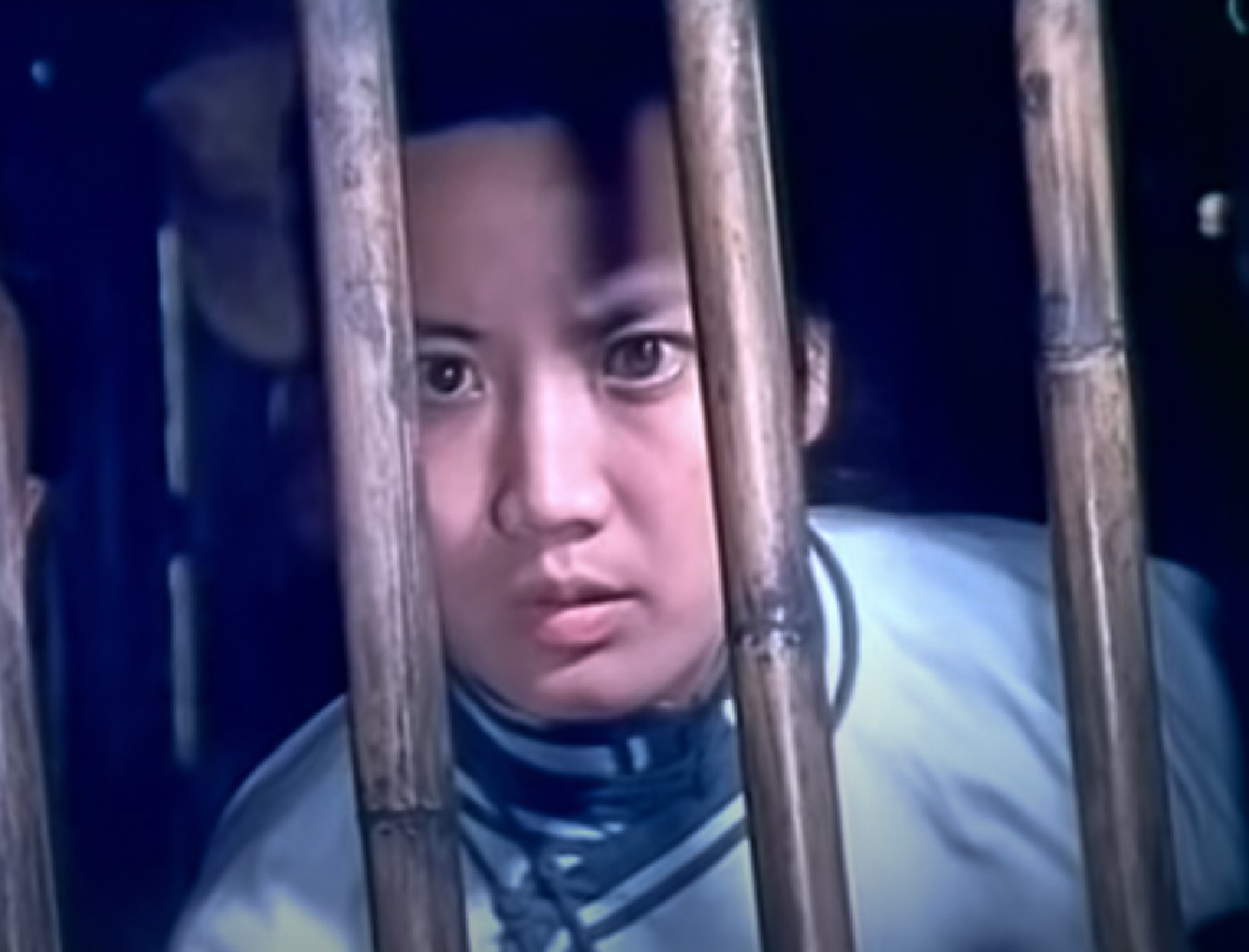 Screenshot: Qiu Jin (Xiuming Li) is looking upset behind bars - from Qiu Jin (1983)