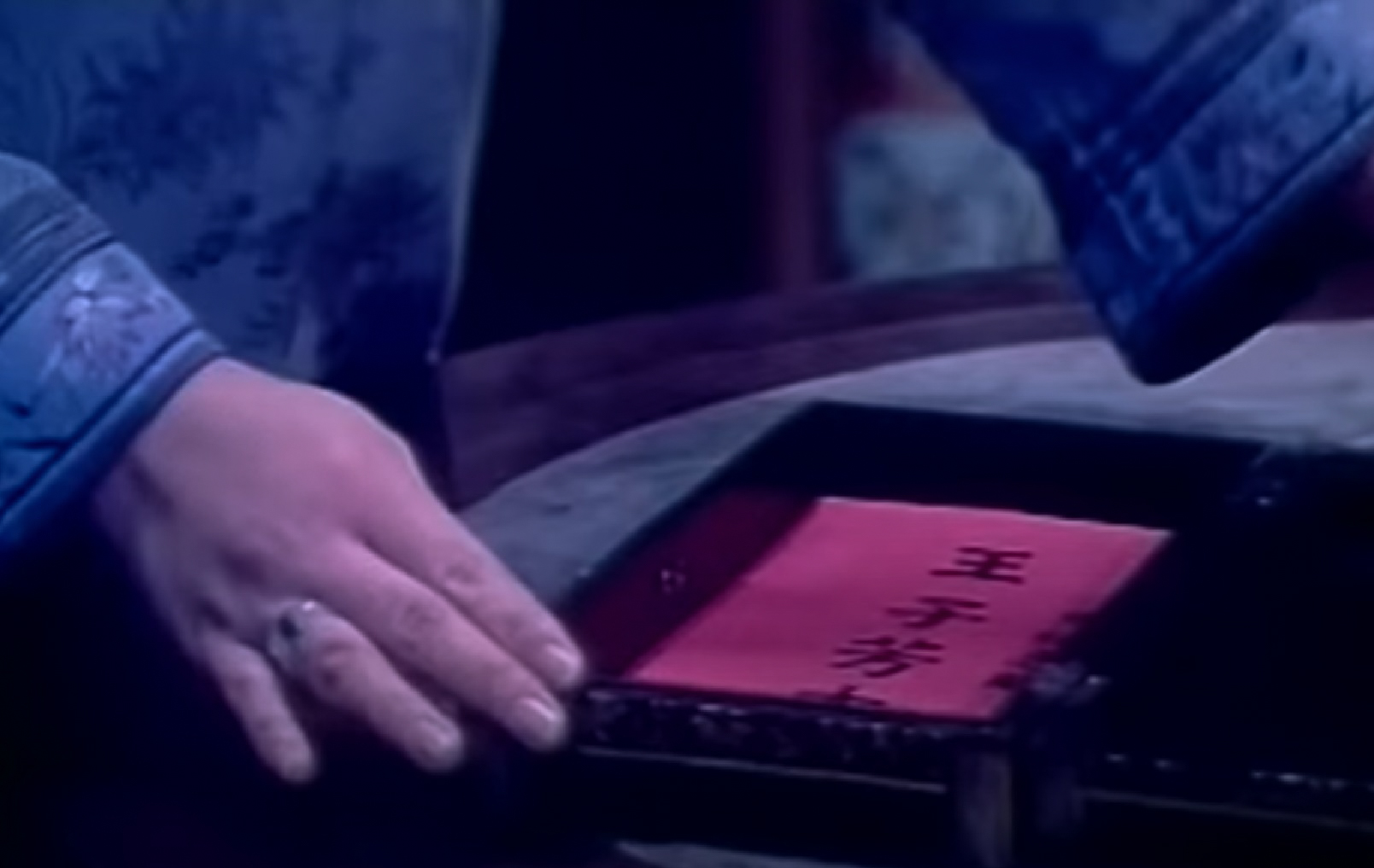 Crop Screenshot: Qiu Jin (Xiuming Li)  is hiding a red envelope in wooden box - from Qiu Jin (1983)