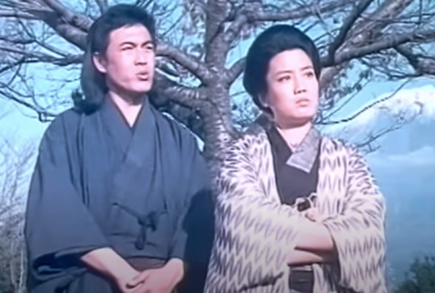 Screenshot: Qiu Jin (Xiuming Li) is standing next to other person outside and looking upset - from Qiu Jin (1983)