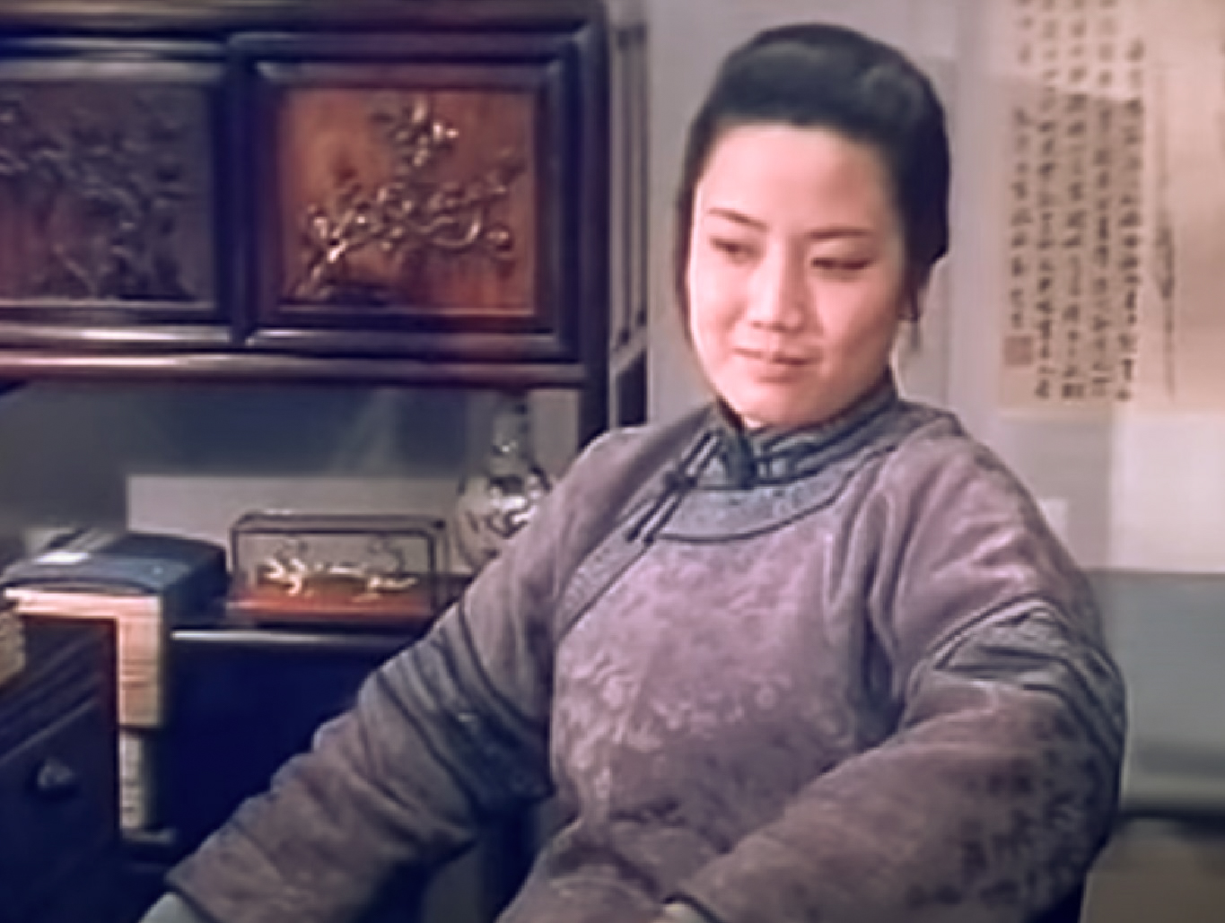 Screanshot: Qiu Jin (Xiuming Li) is seating in room and looking at side - from Qiu Jin (1983)