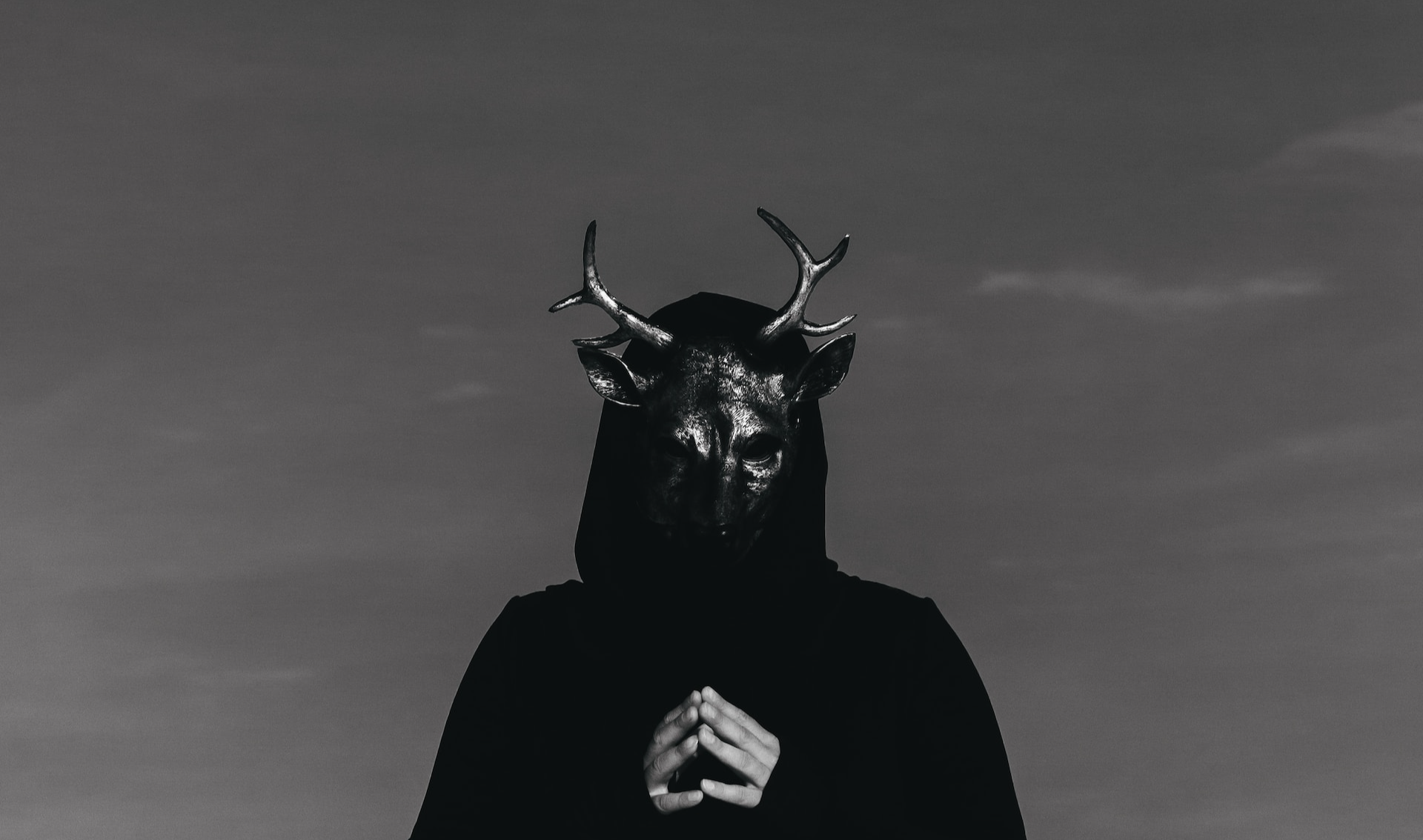 Black and white photo of a man wearing a goat mask