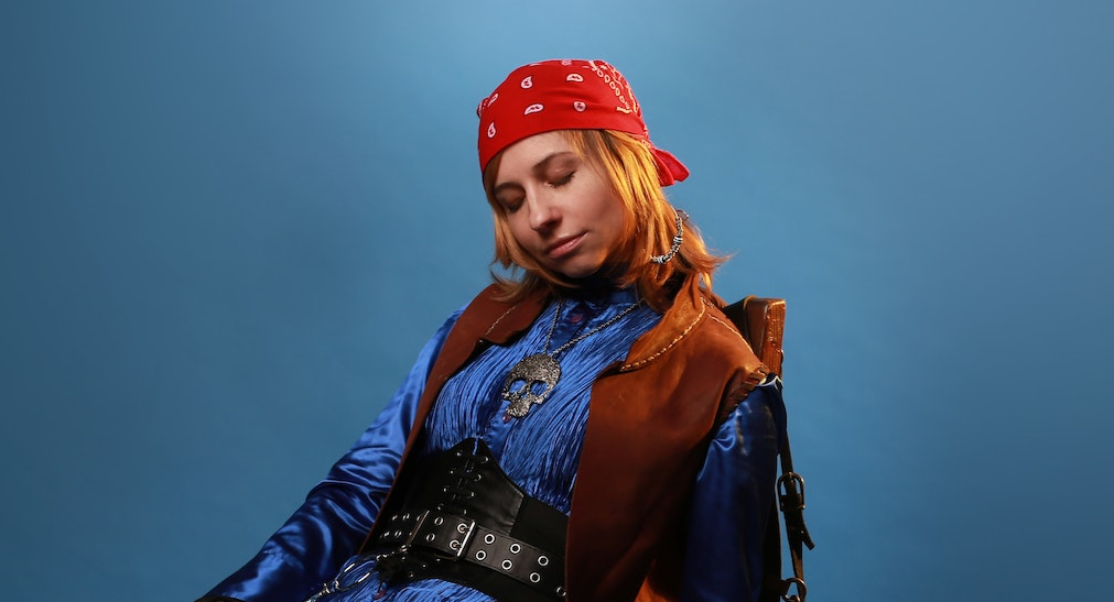 Model in pirate costume on a blue background