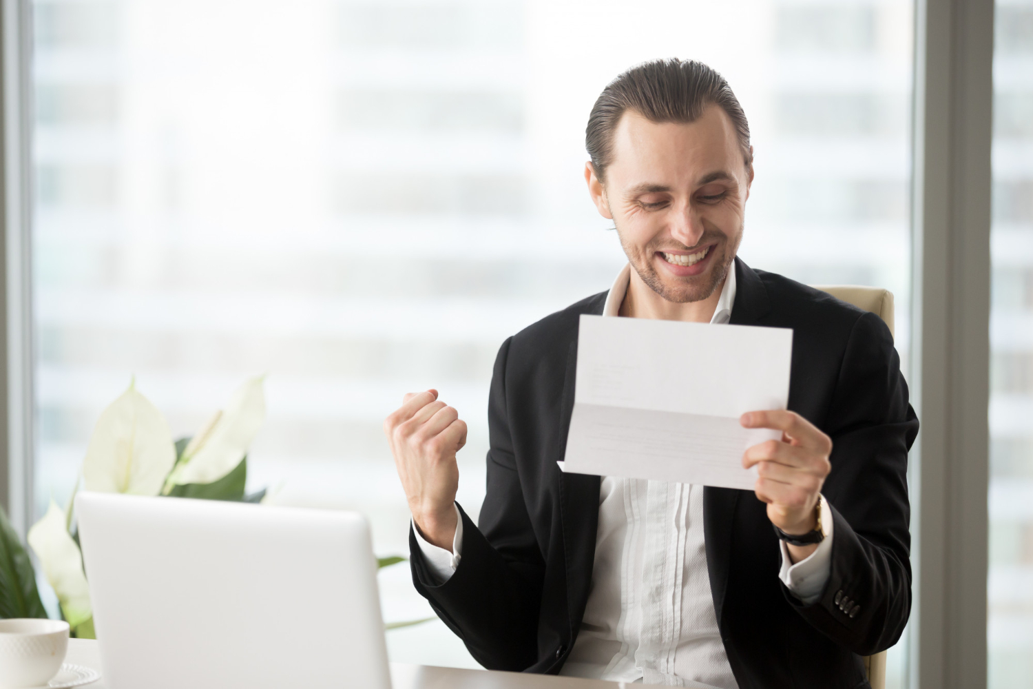 Man is looking happy ,holding a letter in his hands.