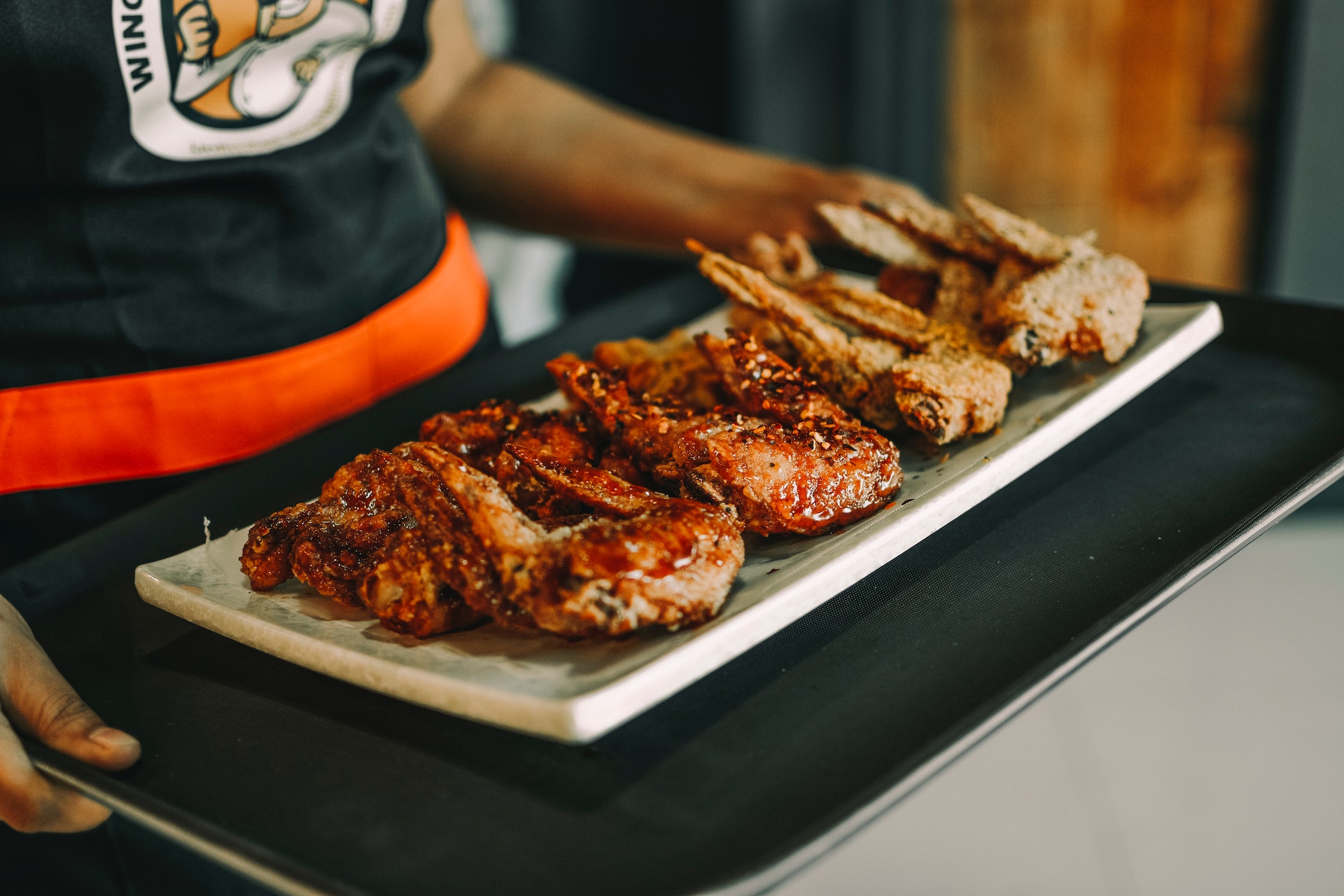 Man caring a Fried Chicken Wings on a Plate