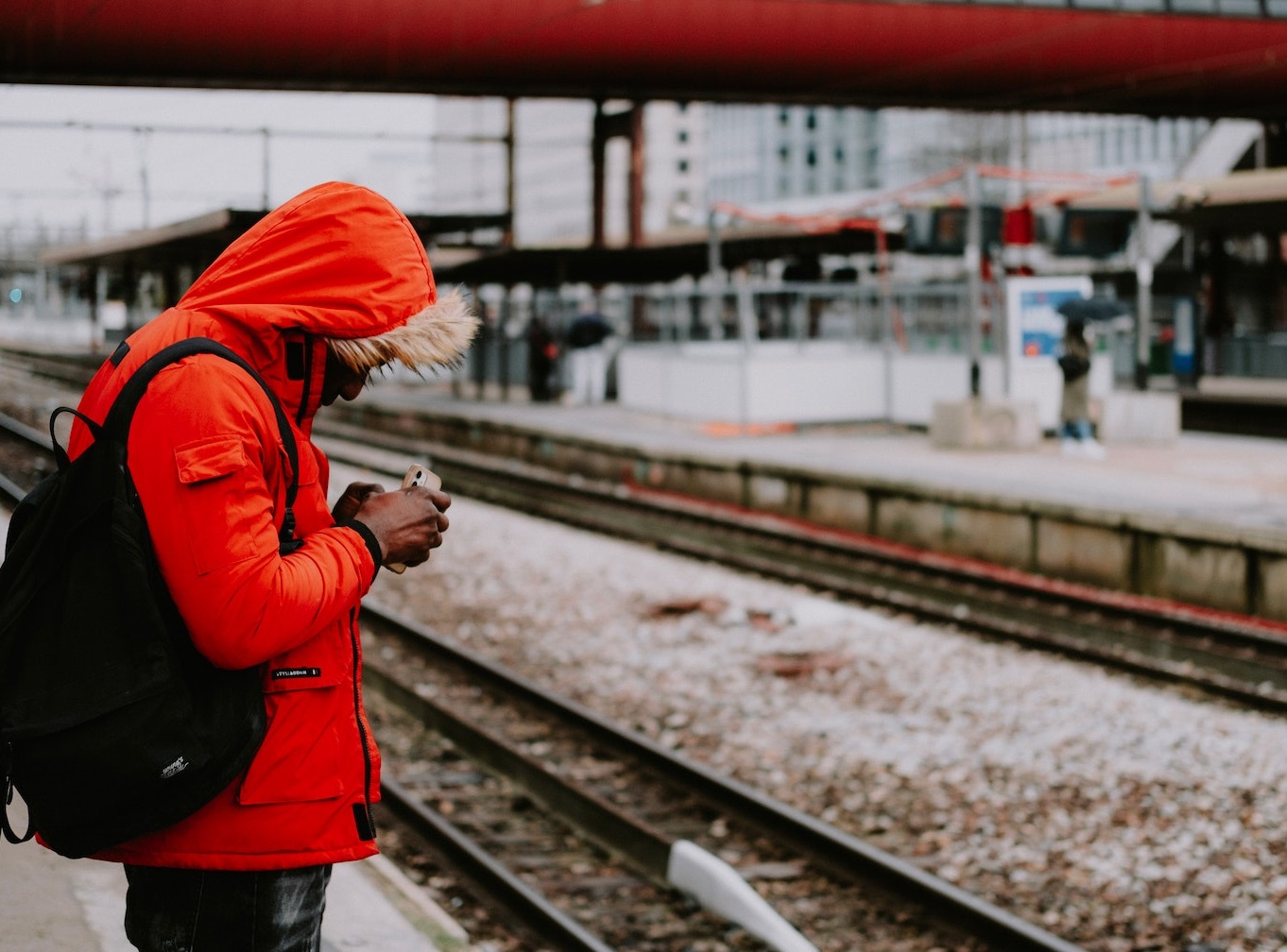 Young man is waiting a train at train station.
