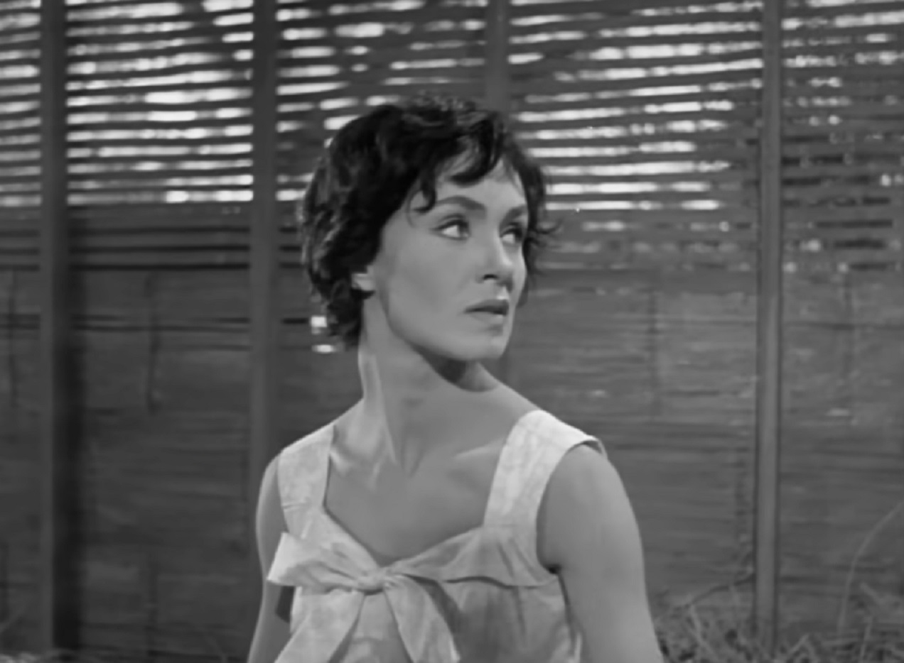 Screenshot: Susan Cabot wearing white dress is looking at side - from Surrender - Hell! (1959)