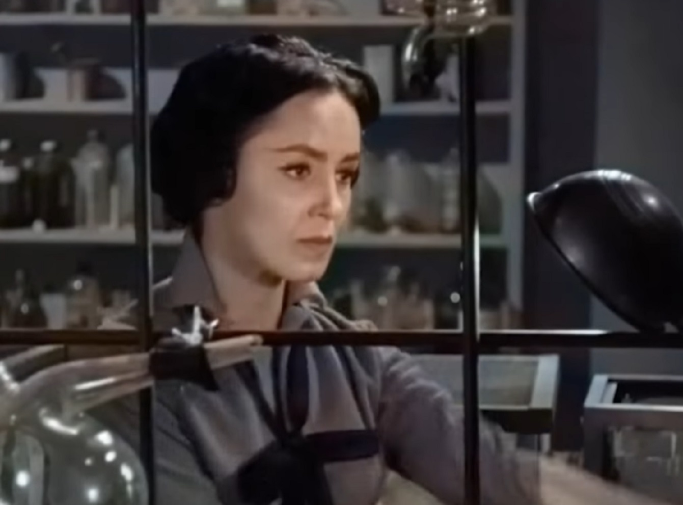 Screenshot: Susan Cabot wearing grey dress is looking at side - The Wasp Woman (1959).