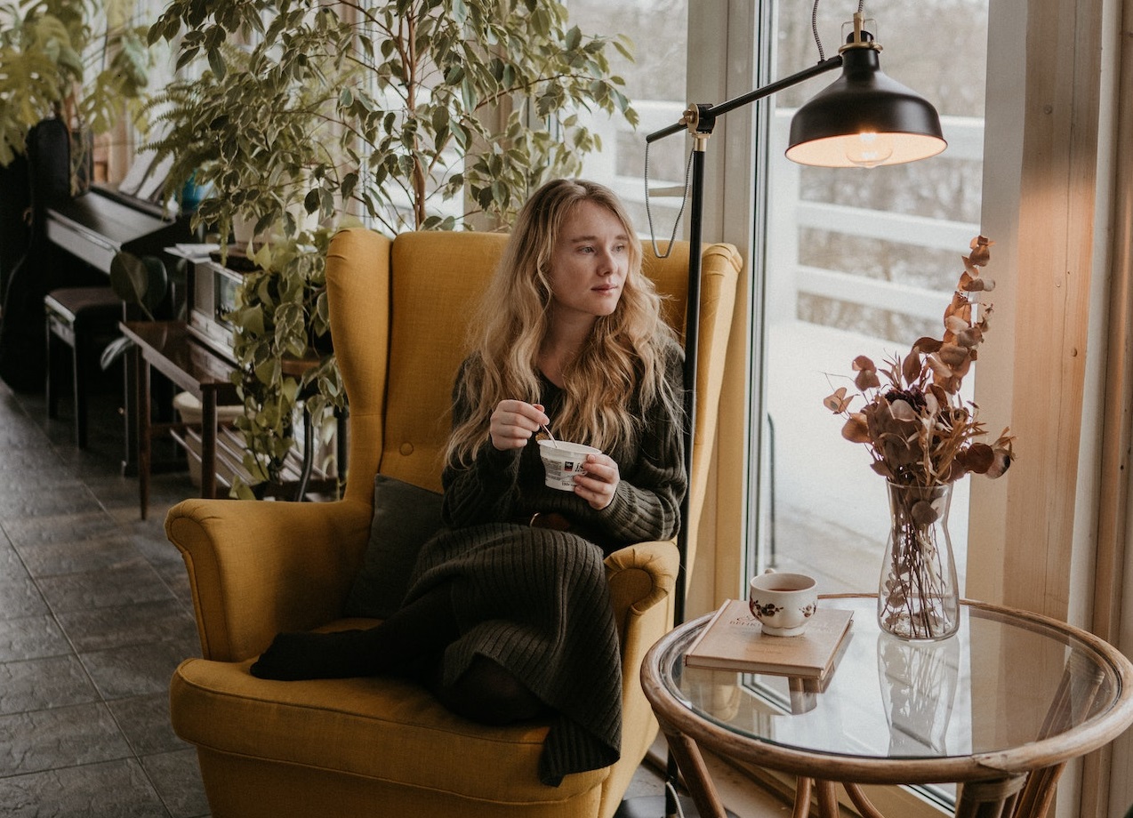 Blonde woman is looking out of the window.