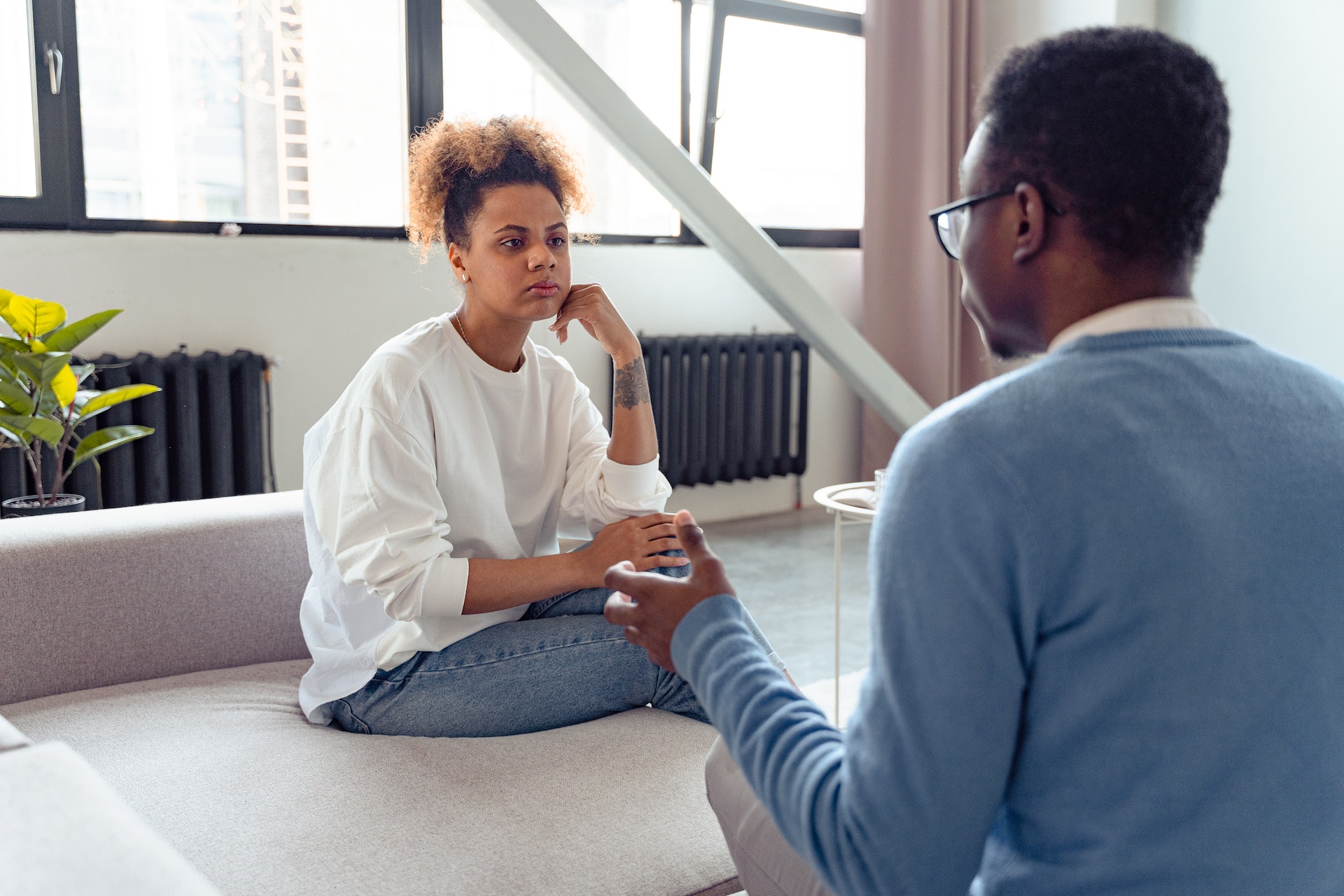 Couple arguing sitting on a sofa at home