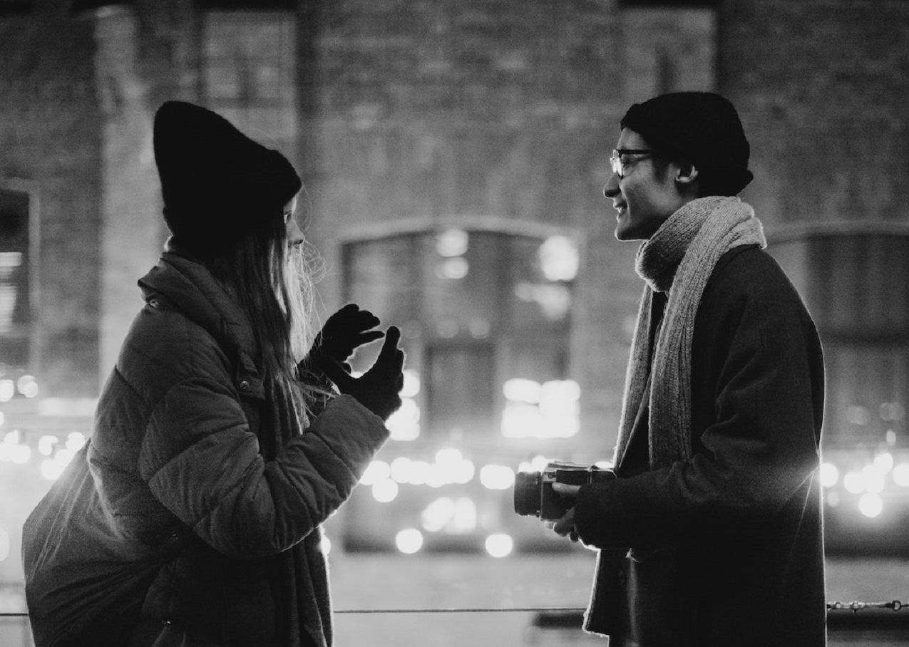 Young couple standing outside and talking.