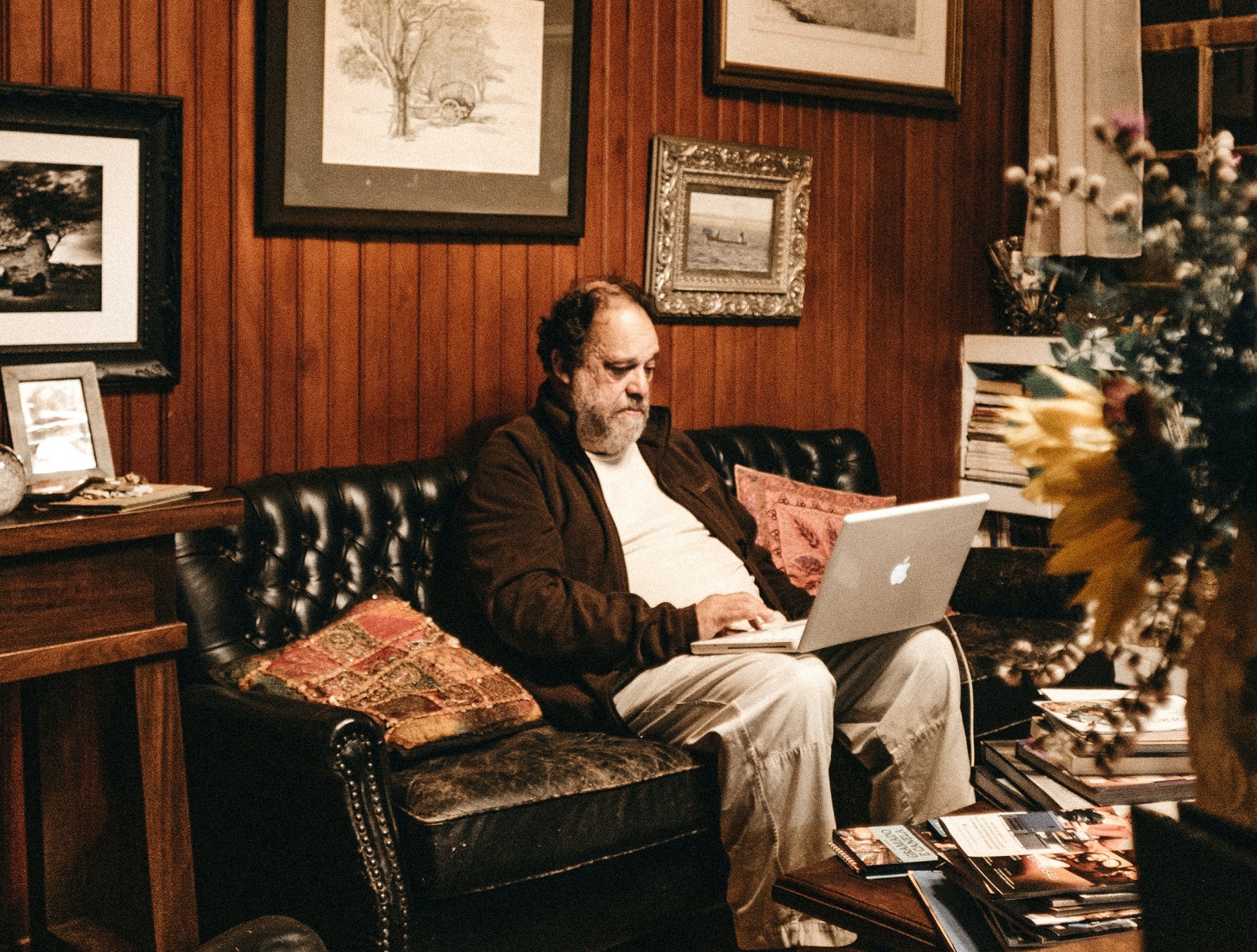 Senior man is working on laptop from home.