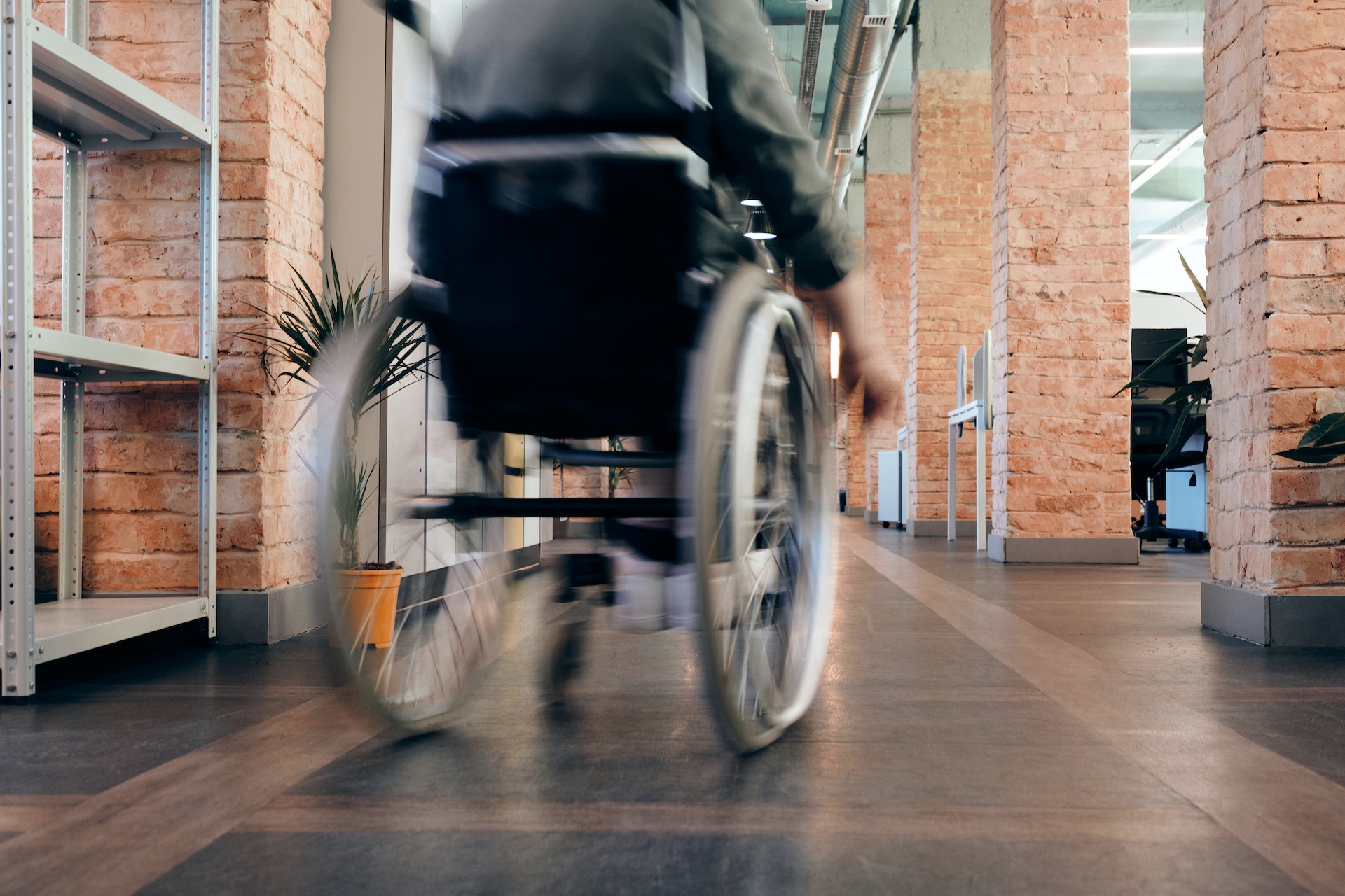 Blurred Photo of Person Using Wheelchair moving in a hallway