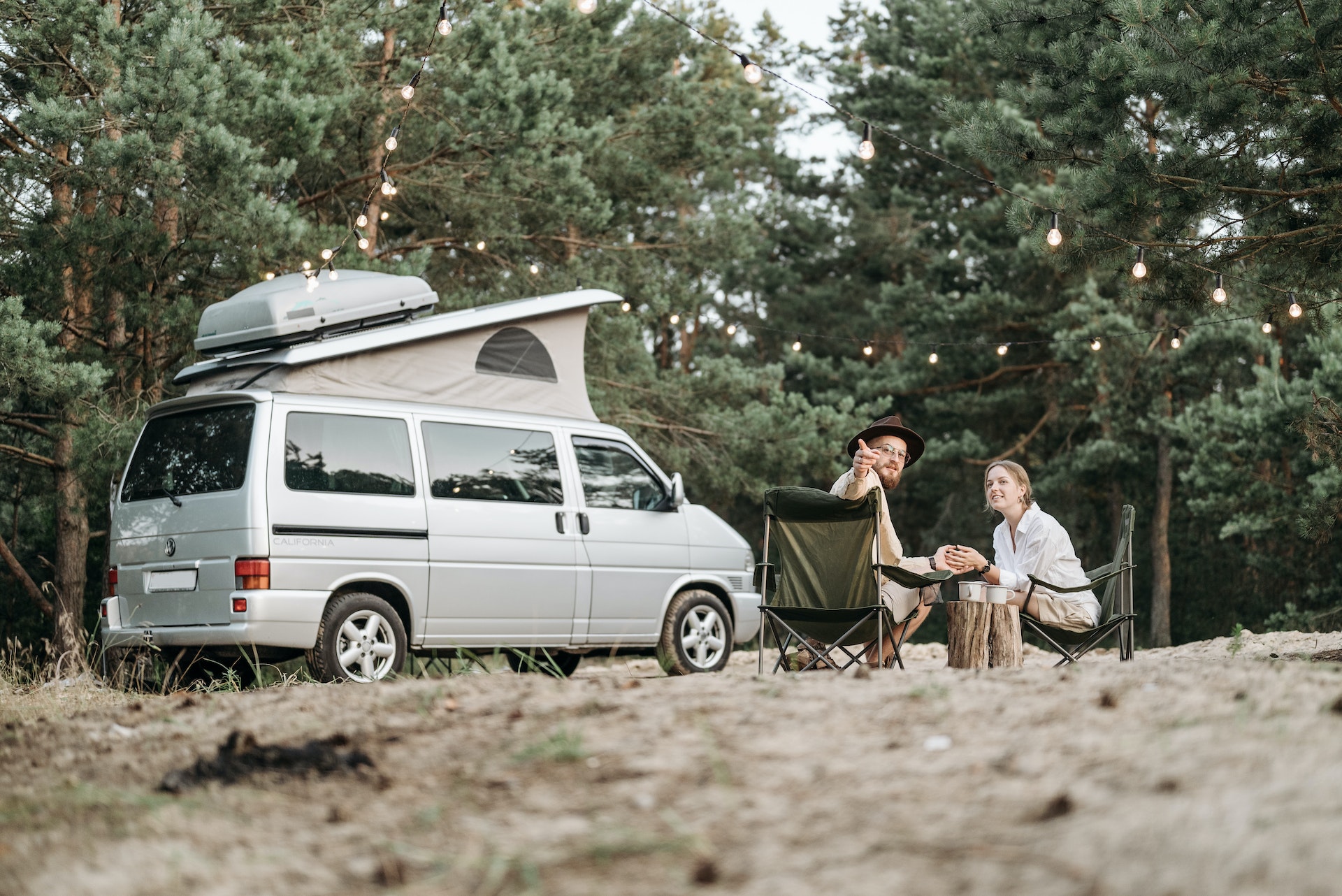 Man and woman sitting on chairs camping  outside