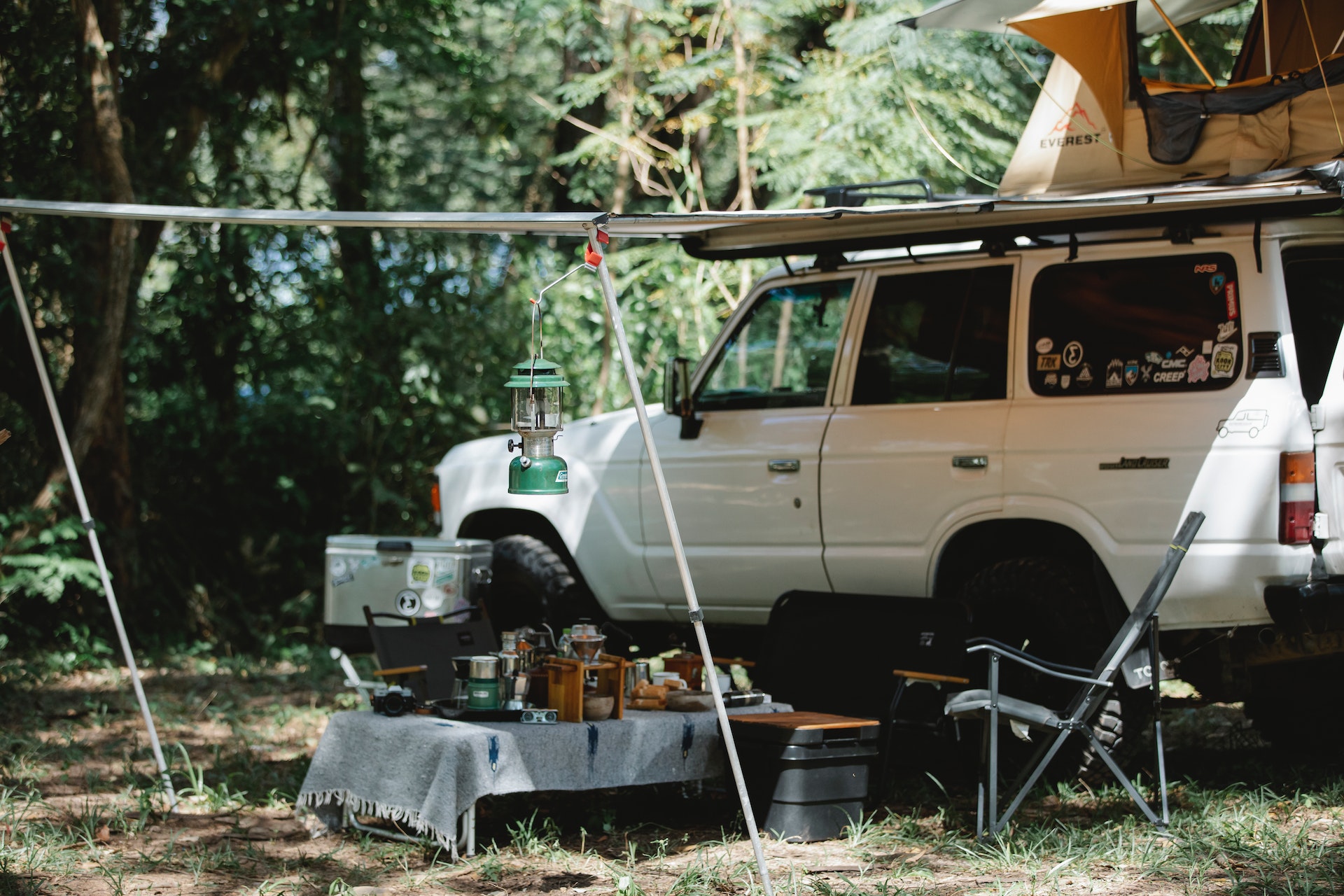 White Off road car with awning and tent placed on roof