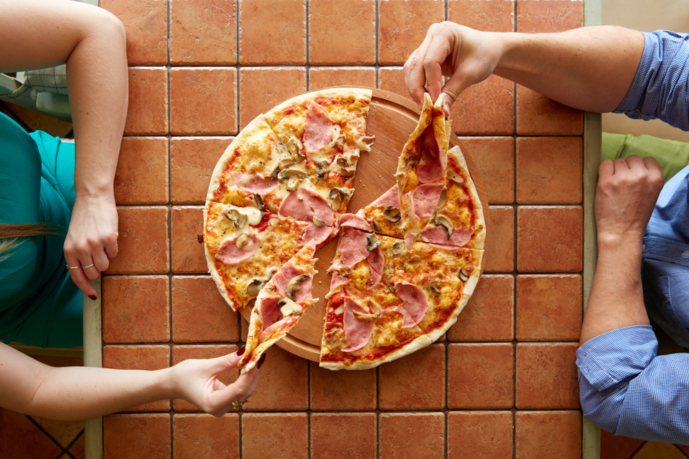 Man and woman on a pizza date sitting across each other