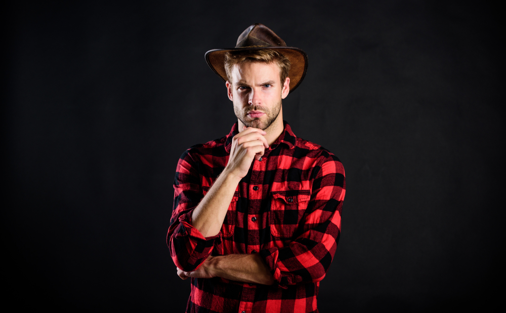 Handsome man in hat  and plaid shirt looking at the camera
