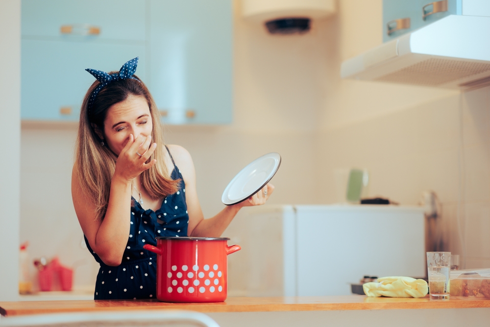 Woman Disgusted by the Bad Smell of the Cooking Pot